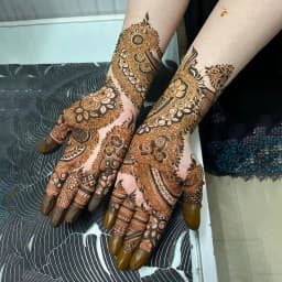 Traditional mehndi featuring intricate mandala and finger detailing